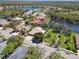 An aerial view shows a beautiful home with a screened-in pool and a lake in a lush, green neighborhood at 742 Shadow Bay Way, Osprey, FL 34229