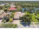 Aerial view of a house near a lake showcasing a tile roof and mature trees in the neighborhood at 742 Shadow Bay Way, Osprey, FL 34229