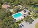 Aerial view of a community pool and clubhouse surrounded by lush trees, with ample seating for relaxation at 742 Shadow Bay Way, Osprey, FL 34229