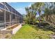 Fenced backyard with a well manicured lawn, vibrant flowers, and a screened-in pool at 742 Shadow Bay Way, Osprey, FL 34229