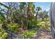 Lush landscaping with a black metal fence creates a private backyard retreat at 742 Shadow Bay Way, Osprey, FL 34229