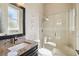 Updated bathroom with a granite countertop vanity, glass-enclosed shower, and modern fixtures at 742 Shadow Bay Way, Osprey, FL 34229