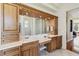 Bathroom with wood cabinets, double sinks, makeup vanity, and tile floor with views to the bedroom at 742 Shadow Bay Way, Osprey, FL 34229