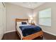 Bedroom with dark hardwood floors, a wood-framed bed with blue accents, and a window with blinds at 742 Shadow Bay Way, Osprey, FL 34229