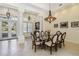 Elegant dining area with a glass-top table, comfortable chairs, and stylish chandelier lighting at 742 Shadow Bay Way, Osprey, FL 34229
