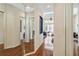Hallway with mirrored walls leading to the bedrooms, featuring wood floors, and vaulted ceilings at 742 Shadow Bay Way, Osprey, FL 34229