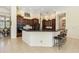 Spacious kitchen features dark wood cabinets, black countertops and island seating at 742 Shadow Bay Way, Osprey, FL 34229