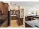 Well-lit kitchen with stone countertops, wood cabinets, island and stainless appliances at 742 Shadow Bay Way, Osprey, FL 34229