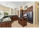 Large kitchen features dark wood cabinetry, stone countertops and island seating at 742 Shadow Bay Way, Osprey, FL 34229
