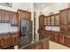 Kitchen features dark wood cabinetry, stainless steel refrigerator, and stone countertops at 742 Shadow Bay Way, Osprey, FL 34229