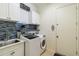 Convenient laundry room with modern washer and dryer, tile backsplash, and ample cabinet space at 742 Shadow Bay Way, Osprey, FL 34229