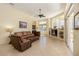 Bright living room with a brown leather sofa set, ceiling fan, and large windows letting in natural light at 742 Shadow Bay Way, Osprey, FL 34229