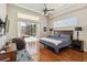 Bright main bedroom featuring wood floors, a ceiling fan, a king bed, and access to the screened pool at 742 Shadow Bay Way, Osprey, FL 34229