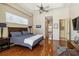 Comfortable main bedroom with a king bed, wood floors, tray ceiling, and an ensuite bathroom entrance at 742 Shadow Bay Way, Osprey, FL 34229