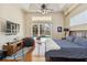 Spacious main bedroom with a king bed, wood floors, tray ceiling, and access to the outdoor screened pool at 742 Shadow Bay Way, Osprey, FL 34229