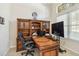 Home office with built-in wooden shelving, a spacious desk, and ample natural light, creating a productive workspace at 742 Shadow Bay Way, Osprey, FL 34229
