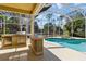 Outdoor kitchen area with built-in barbecue near a screened-in pool and spa for ultimate convenience at 742 Shadow Bay Way, Osprey, FL 34229