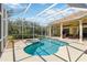 Inviting screened-in pool and spa area surrounded by lush landscaping and a covered patio at 742 Shadow Bay Way, Osprey, FL 34229