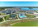 Aerial view of community amenities including a pool, clubhouse, playground, and tennis courts at 7712 Saloon Ln, Sarasota, FL 34240