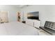 Bright bedroom featuring hard surface floors, a large TV, and neutral colors, and access to ensuite bathroom at 7712 Saloon Ln, Sarasota, FL 34240