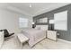 Modern bedroom featuring tray ceilings, a gray accent wall, and bright white furniture at 7712 Saloon Ln, Sarasota, FL 34240