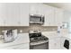 Well-equipped kitchen with stainless appliances, quartz counters, and modern fixtures at 7712 Saloon Ln, Sarasota, FL 34240