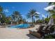 Community pool with surrounding lounge area, mature landscaping, and palm tree accents at 7977 Bowspirit Way, Lakewood Ranch, FL 34202