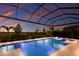 Pool area featuring water features, sun loungers, and covered enclosure at sunset at 7977 Bowspirit Way, Lakewood Ranch, FL 34202