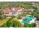 Aerial view showcases the opulent clubhouse and pool area, set amidst lush landscaping and palms at 8348 Catamaran Cir, Lakewood Ranch, FL 34202