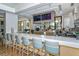 Stylish bar area with a long countertop, comfortable seating, and mounted televisions at 8348 Catamaran Cir, Lakewood Ranch, FL 34202
