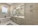 Elegant bathroom with grey cabinets, standalone tub, glass shower, and modern lighting at 8348 Catamaran Cir, Lakewood Ranch, FL 34202