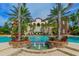 Gorgeous community pool with fountains and palm trees with home in the background at 8348 Catamaran Cir, Lakewood Ranch, FL 34202