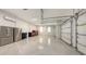 Large garage featuring epoxy floors, dual refrigerators, and multiple garage doors for ample vehicle parking at 8348 Catamaran Cir, Lakewood Ranch, FL 34202