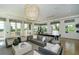 Comfortable lounge area with ample seating, a large chandelier, and scenic views through expansive windows at 8348 Catamaran Cir, Lakewood Ranch, FL 34202