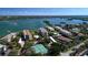 Aerial view showcasing waterfront condos with tennis courts and lush landscaping at 8767 Midnight Pass Rd # 403F, Sarasota, FL 34242