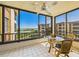 Enclosed balcony with tile floors, a ceiling fan, and scenic views creates a cozy outdoor space for relaxation at 8767 Midnight Pass Rd # 403F, Sarasota, FL 34242