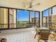 Spacious balcony with chairs offers water views for enjoying the outdoors with shade provided by a ceiling fan at 8767 Midnight Pass Rd # 403F, Sarasota, FL 34242