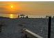 Peaceful beach scene with a tent, people, bench, and a beautiful sunrise at 8767 Midnight Pass Rd # 403F, Sarasota, FL 34242