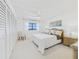 Calm bedroom with a king bed, white interior, and tranquil ocean view through a window at 8767 Midnight Pass Rd # 403F, Sarasota, FL 34242