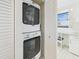 Laundry area including a stacked washer and dryer, with a window and workspace nearby at 8767 Midnight Pass Rd # 403F, Sarasota, FL 34242