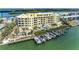Luxury yellow waterfront condominium with private boat slips, lush landscaping, and waterfront pool at 9122 Midnight Pass Rd # 24, Sarasota, FL 34242