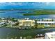 Picturesque aerial perspective of the condo building with boat docks and beautiful bay views in the background at 9122 Midnight Pass Rd # 24, Sarasota, FL 34242