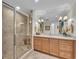 Elegant bathroom features a glass enclosed shower, large mirror, and vanity with a white countertop at 9122 Midnight Pass Rd # 24, Sarasota, FL 34242