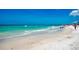 Scenic beach with white sand, clear turquoise water, and a few people enjoying the sunny day at 9122 Midnight Pass Rd # 24, Sarasota, FL 34242