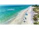 Inviting beach with turquoise water, white sand, and blue canopies provides a relaxing coastal getaway at 9122 Midnight Pass Rd # 24, Sarasota, FL 34242