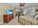 Bright bedroom featuring a decorative ceiling fan, shuttered windows, and a private balcony at 9122 Midnight Pass Rd # 24, Sarasota, FL 34242
