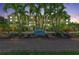 Exterior of the condo building, showcasing lush landscaping and a welcoming Somerset Cay sign at dusk at 9122 Midnight Pass Rd # 24, Sarasota, FL 34242