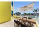 Outdoor dining area on a spacious balcony with a large umbrella, offering beautiful views of the waterfront at 9122 Midnight Pass Rd # 24, Sarasota, FL 34242