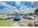 Commercial parking lot with a variety of cars and building in the background with cloudy skies above at 9122 Midnight Pass Rd # 24, Sarasota, FL 34242