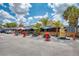 Exterior of an outdoor restaurant featuring tiki huts, statues, picnic tables, and colorful umbrellas at 9122 Midnight Pass Rd # 24, Sarasota, FL 34242
